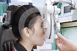 Young woman examining eyes with her optometrist