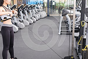 Young woman execute exercise with machine in fitness center. fem