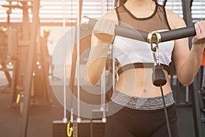 Young woman execute exercise with machine in fitness center. fem