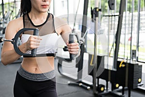 Young woman execute exercise with machine in fitness center. fem