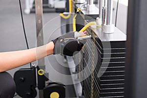 young woman execute exercise with pull down machine in fitness c