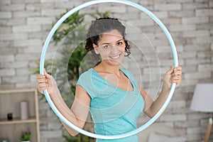 young woman exercising with hula hoop