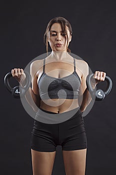 Young woman exercising with kettlebells