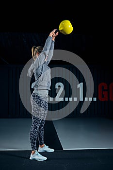 Young woman exercising with kettlebells at the gym. Squats squatting swing WOD fitness gym. Fitness woman workout with
