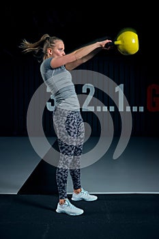 Young woman exercising with kettlebells at the gym. Squats squatting swing WOD fitness gym. Fitness woman workout with
