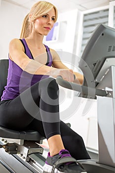 Young woman exercising on a machine