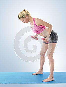 Young woman exercising on mat