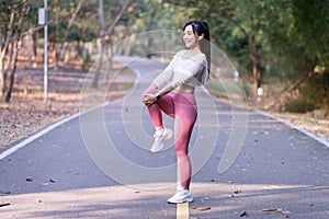 Young woman exercising in the morning at a public park on a bright sunny day