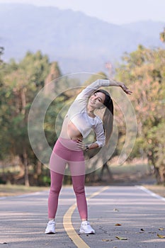 Young woman exercising in the morning at a public park on a bright sunny day