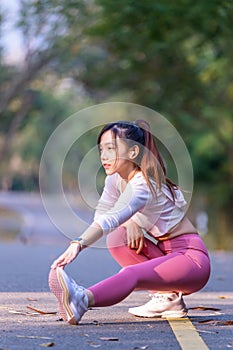 Young woman exercising in the morning at a public park on a bright sunny day