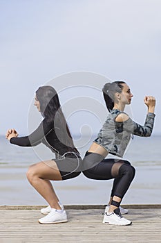 Young woman exercising in the morning by the sea