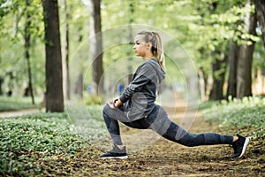 Young woman exercising at park during sunset. Beautiful athletic woman doing her stretches in the park. Sporty woman stretching af