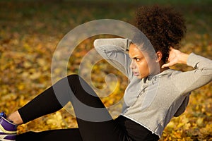 Young woman exercising sit ups outdoors