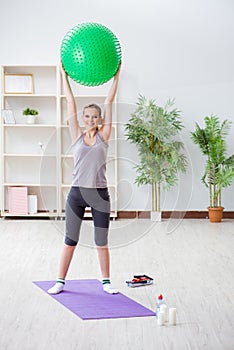 The young woman exercising with stability ball in gym