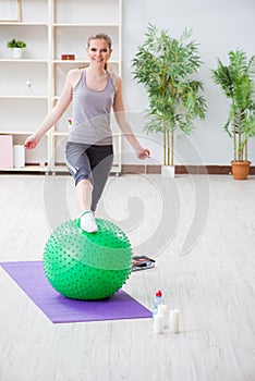 The young woman exercising with stability ball in gym