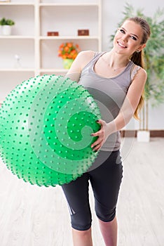 The young woman exercising with stability ball in gym