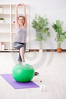 The young woman exercising with stability ball in gym