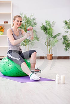 The young woman exercising with stability ball in gym