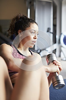 Young Woman Exercising With Weight In Gym