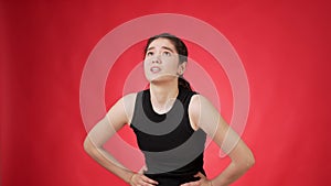 Young woman experiencing stomach pain against red background