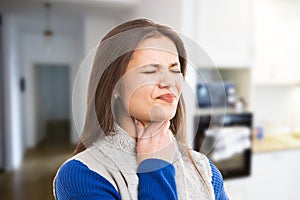 Young woman experiencing throat ache photo