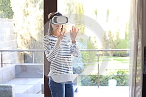 Young woman experiencing virtual reality touching air with hands
