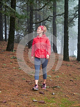 Young woman exploring stunning autumn foggy forest