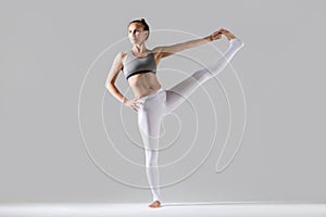 Young woman in Extended Hand to Big Toe pose, studio