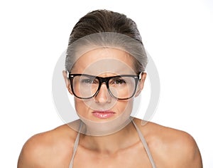 Young woman in eyeglasses looking attentively in camera