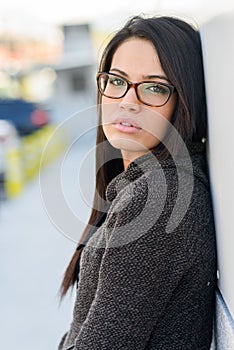 Young woman with eyeglasses in urban background