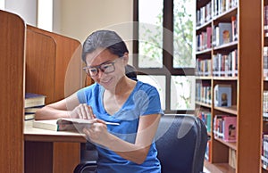 Young woman in eyeglasses for vision corrective reading literature book