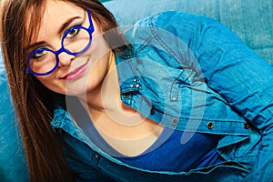 Young woman face in blue glasses