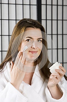 Young woman with face cream