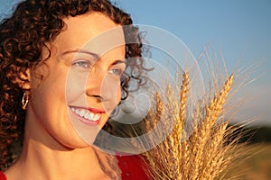 Young woman face with earns on wheaten field