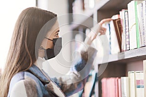 Young woman with face mask in a bookstore