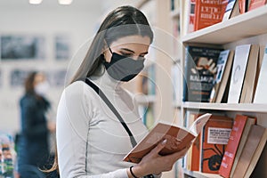 Young woman with face mask in a bookstore