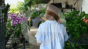 Young Woman in Face Mask Going, Holding Pot with Plant in Hands