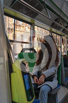 Young woman is face mask is travelling by bus. Precautions in public transport