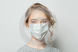 Young woman in a face mask on white background. Woman in medical mack. Flu epidemic and virus protection concept photo