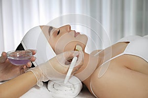 Young woman during face peeling procedure