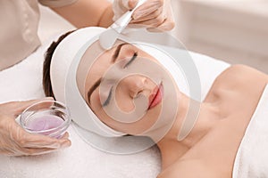 Young woman during face peeling procedure