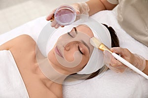 Young woman during face peeling procedure