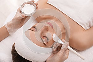 Young woman during face peeling procedure