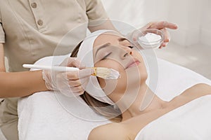 Young woman during face peeling procedure