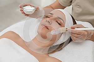 Young woman during face peeling procedure in salon