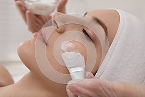 Young woman during face peeling procedure in salon, closeup