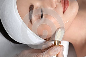 Young woman during face peeling procedure in salon, closeup