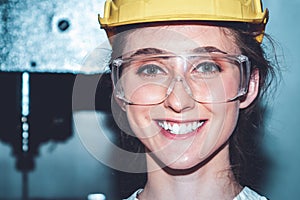 Young woman factory worker close up portrait in manufacturing job factory