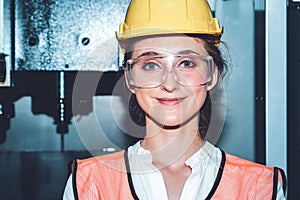 Young woman factory worker close up portrait in manufacturing job factory
