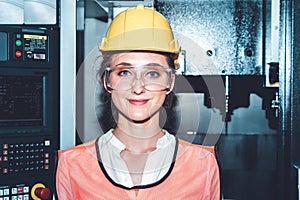 Young woman factory worker close up portrait in manufacturing job factory